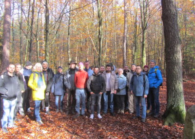 Gruppenfoto mit 20 Menschen von den ABC-Tischen, die im Herbst im Wald spazieren